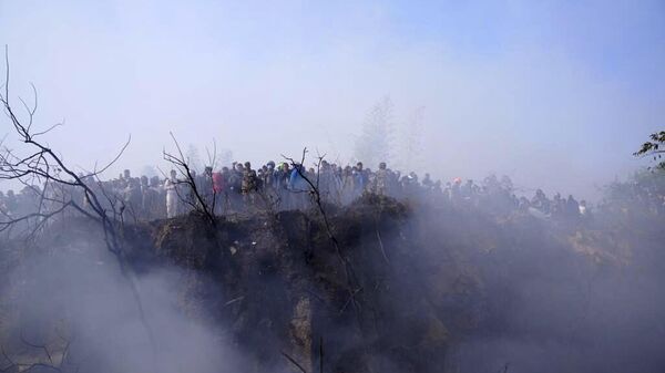 Locals watch the wreckage of a passenger plane in Pokhara, Nepal, Sunday, Jan.15, 2023. - Sputnik India