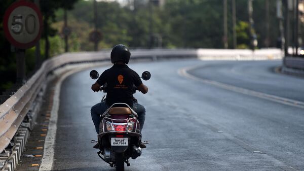 Praveen Gaikwad, a 32-year-old delivery man working with Swiggy, an online food delivery application, rides his bike on a deserted road to deliver an order to a customer during a government-imposed nationwide lockdown as a preventive measure against the spread of the COVID-19 coronavirus in Mumbai on April 7, 2020. - Sputnik भारत