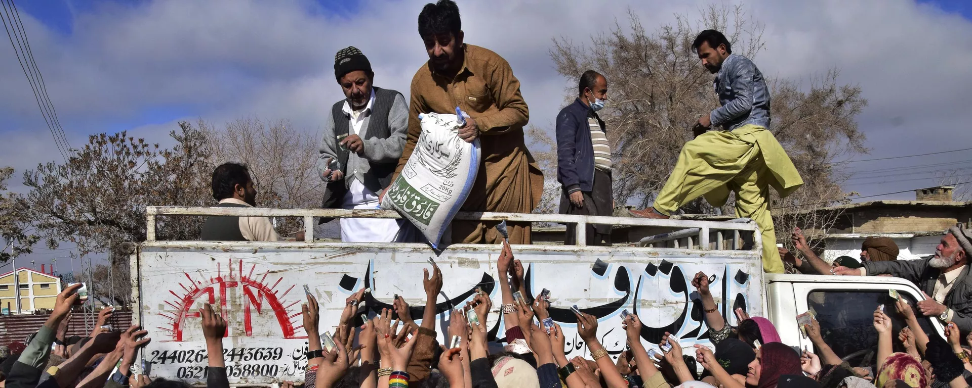 People jostle to buy subsidized sacks of wheat-flour from a sale point in Quetta, Pakistan, Thursday, Jan. 12, 2023. - Sputnik India, 1920, 12.02.2023