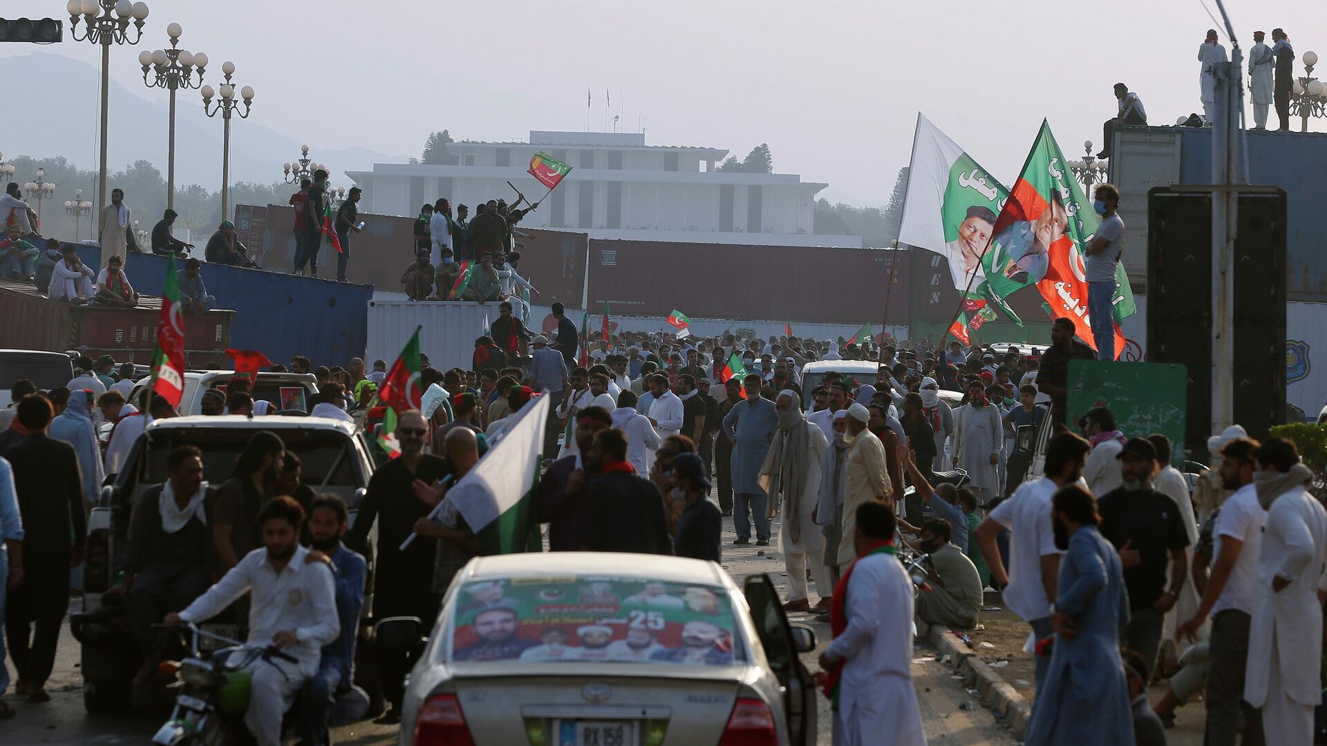 Supporters of Pakistan’s defiant former Prime Minister Imran Khan stand on shipping containers after removing them to open a road during an anti-government rally in Islamabad, Pakistan, Thursday, May 26, 2022. - Sputnik India, 1920, 16.01.2023