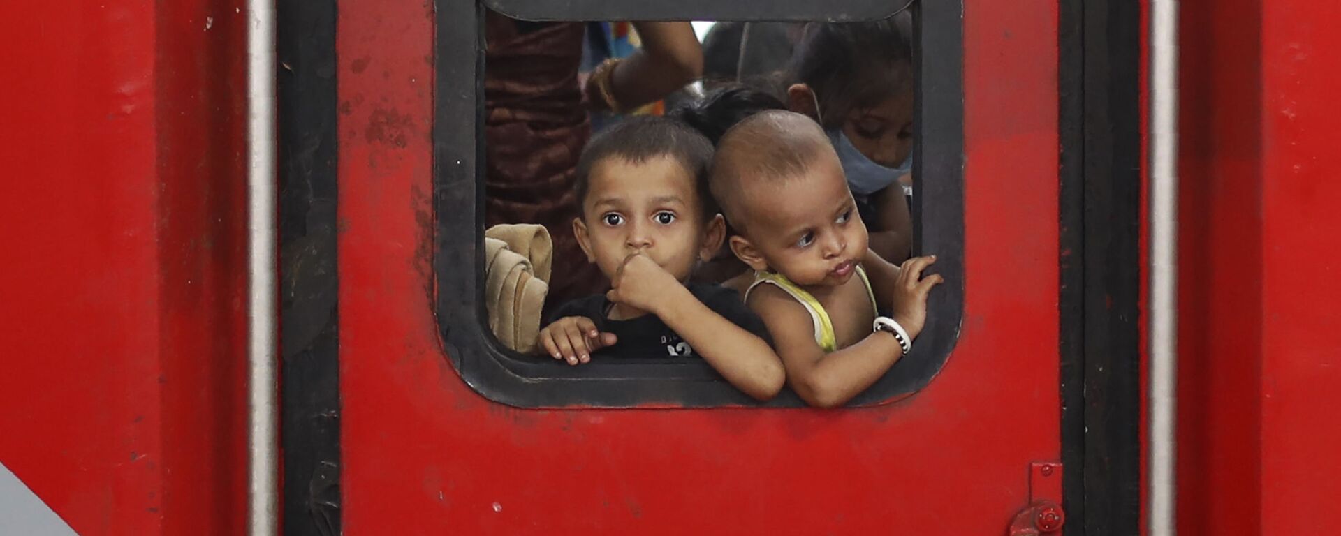 In this Saturday, May 30, 2020 photo, Indian migrant worker's children peer out from the window of their train in Prayagraj, India, as they return to villages - Sputnik भारत, 1920, 18.01.2023