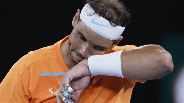 Rafael Nadal of Spain wipes the sweat from his face during his second round match against Mackenzie McDonald of the U.S., at the Australian Open tennis championship in Melbourne, Australia, Wednesday, Jan. 18, 2023. - Sputnik India