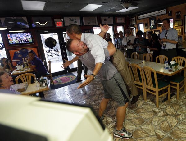 Former President Barack Obama, right, is picked-up and lifted off the ground by Scott Van Duzer, left, owner of Big Apple Pizza and Pasta Italian Restaurant during an unannounced stop, Sunday, Sept. 9, 2012, in Ft. Pierce, Fla. (AP Photo/Pablo Martinez Monsivais) - Sputnik India