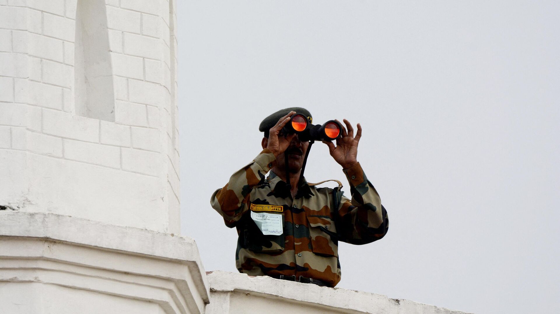 An Indian paramilitary force personnel uses a pair of binoculars form a high position to monitor the speech of Rahul Gandhi, president of India's main opposition Congress party, during public rally ahead of India's general elections at Khumulwng, on the outskirts of Agartala, the capital of northeastern state of Tripura on March 20, 2019. - Sputnik India, 1920, 19.01.2023
