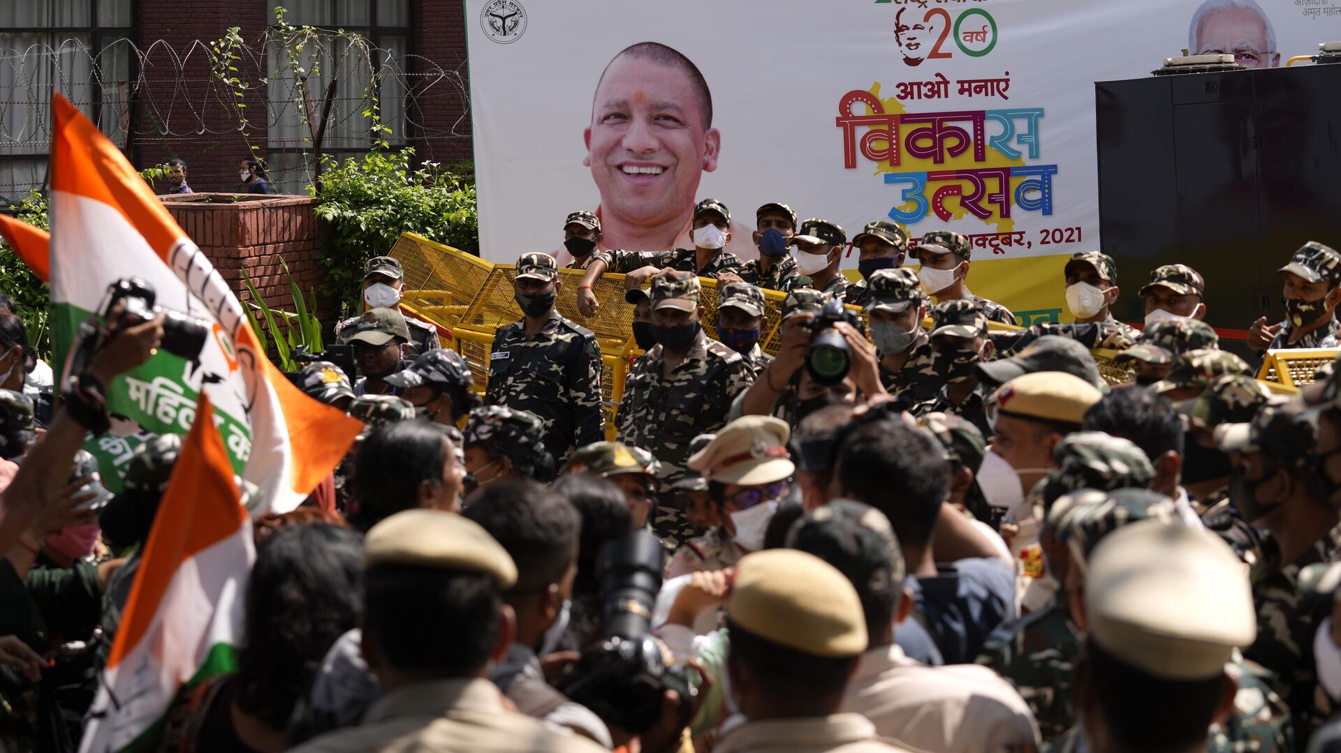 A banner of development festival displays a photograph of Uttar Pradesh Chief Minister Yogi Adityanath as paramilitary force soldiers detain activists of Congress party's youth wing protesting against Sunday's killing of four farmers in Uttar Pradesh state after being run over by a car owned by India's junior home minister in New Delhi, India, Monday, Oct. 4, 2021. - Sputnik India, 1920, 19.01.2023