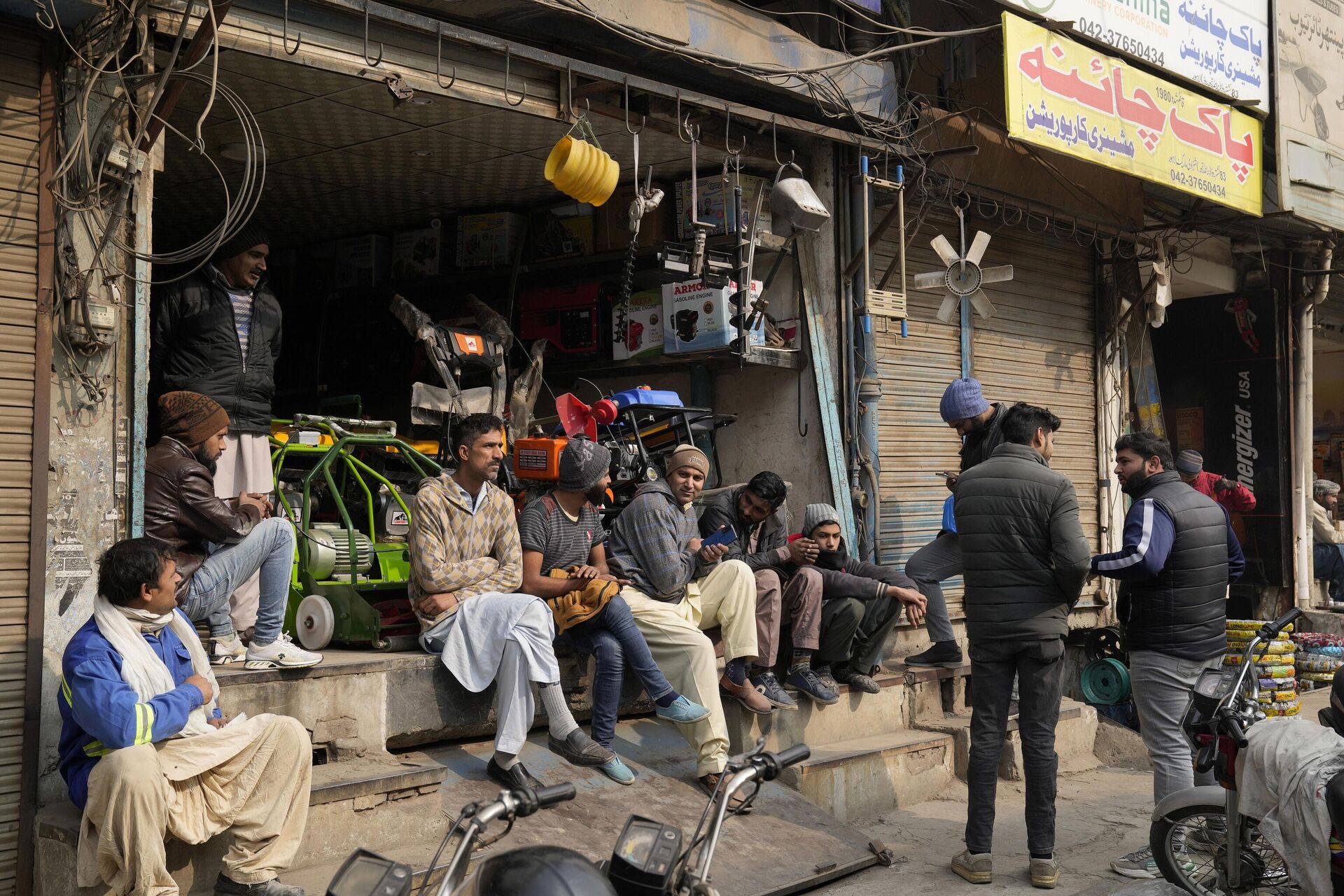 Shopkeepers and workers wait for electric power at a market following a power breakdown across the country, in Lahore, Pakistan, Monday, Jan. 23, 2023. - Sputnik India, 1920, 06.12.2023