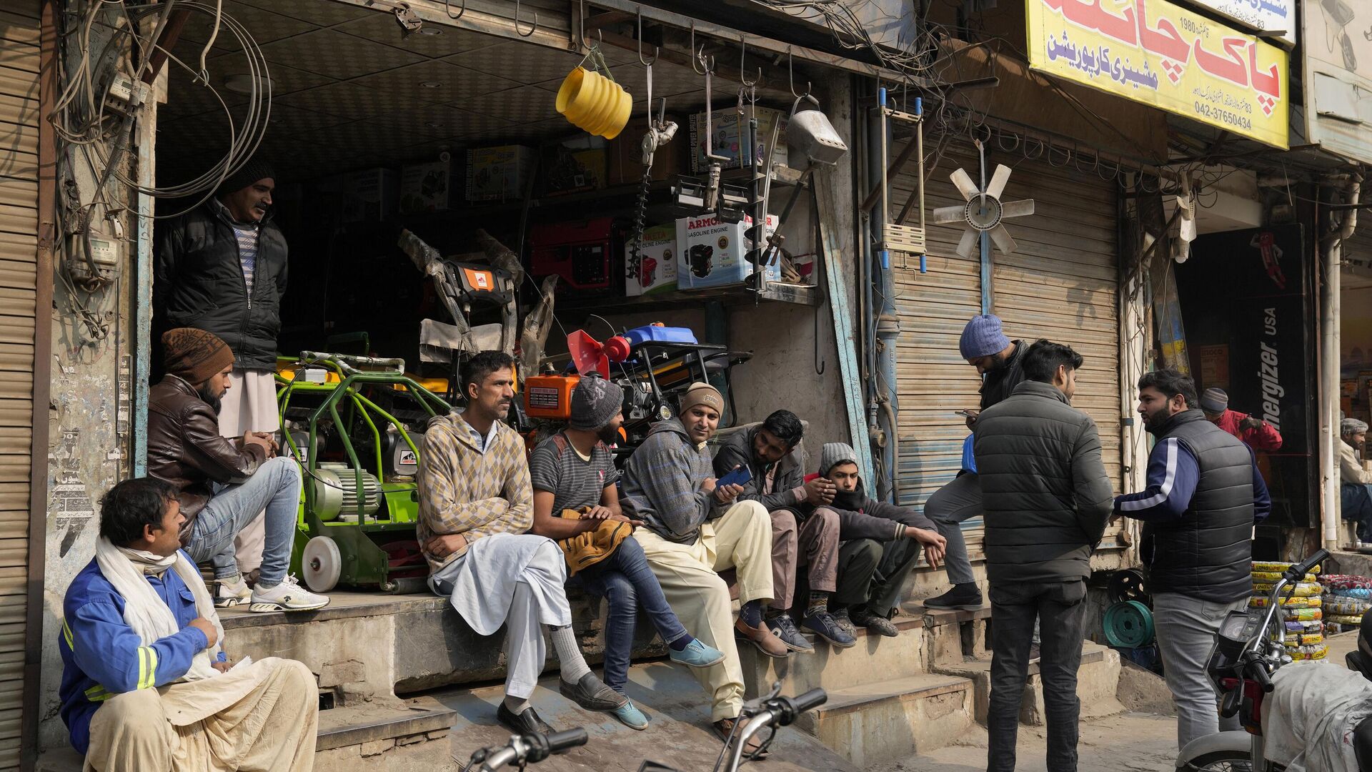 Shopkeepers and workers wait for electric power at a market following a power breakdown across the country, in Lahore, Pakistan, Monday, Jan. 23, 2023. - Sputnik India, 1920, 31.01.2023
