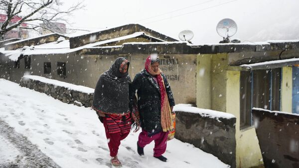 People walk on a snow-covered road in Joshimath, in the northern Indian state of Uttarakhand, Friday, Jan. 20, 2023. - Sputnik भारत