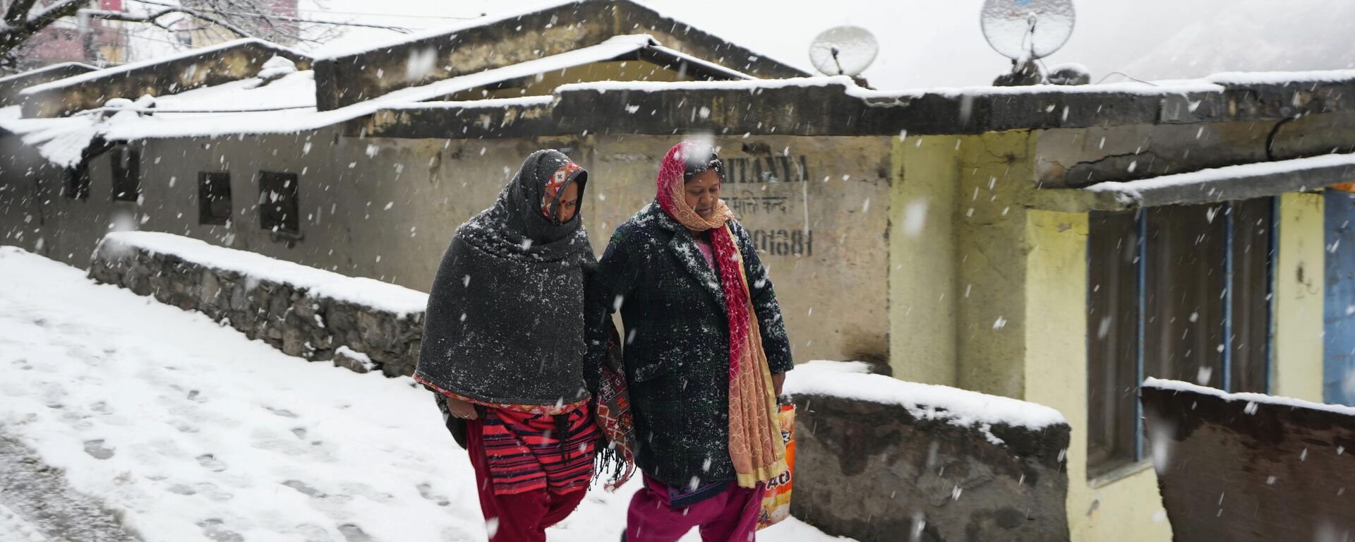 People walk on a snow-covered road in Joshimath, in the northern Indian state of Uttarakhand, Friday, Jan. 20, 2023. - Sputnik भारत, 1920, 23.01.2023