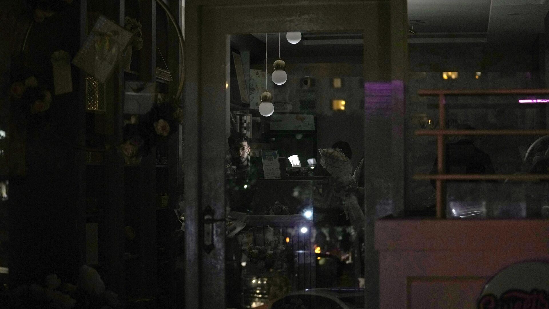 A shopkeeper use a battery light at his shop during a nationwide power outage in Islamabad, Pakistan, Monday, Jan. 23, 2023. - Sputnik India, 1920, 24.01.2023
