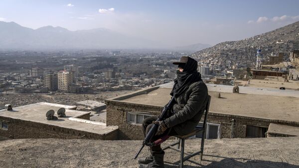 A Taliban fighter sits as he watches the area in Kabul, Afghanistan, Monday, Dec. 26, 2022. - Sputnik भारत