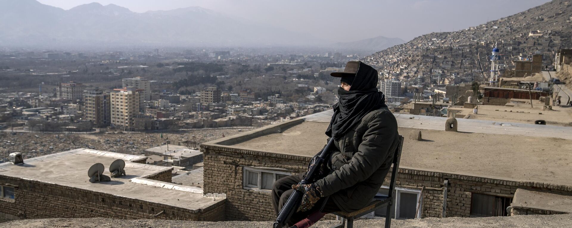 A Taliban fighter sits as he watches the area in Kabul, Afghanistan, Monday, Dec. 26, 2022. - Sputnik India, 1920, 24.06.2023