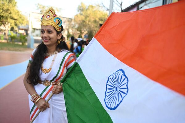A school student holds the flag of India before taking part in a ceremony during the Republic Day celebrations at the railway sports complex ground in Secunderabad, the twin city of Hyderabad on January 26, 2023. - Sputnik India