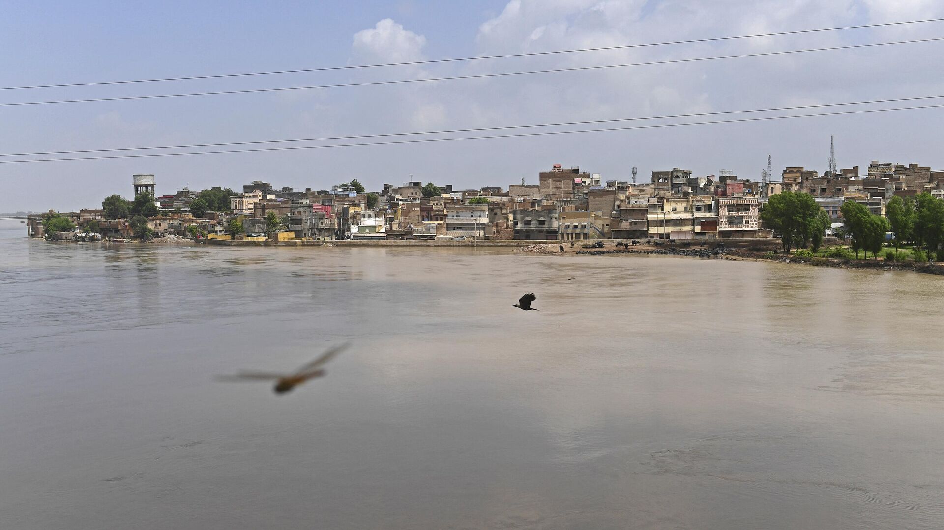 A general view of swollen river Indus is pictured along with residential area in flood hit Sukkur of Sindh province on August 28, 2022. (Photo by Asif HASSAN / AFP) - Sputnik India, 1920, 28.01.2023