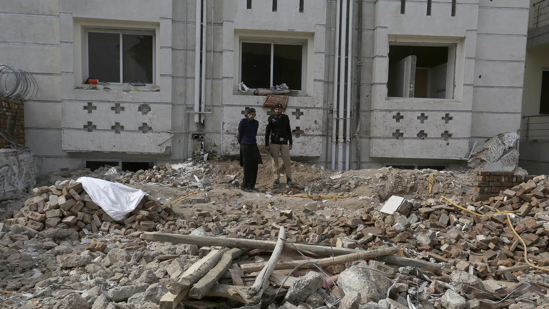 Police officers examine the site of Monday's suicide bombing in Peshawar, Pakistan, Feb. 2, 2023.