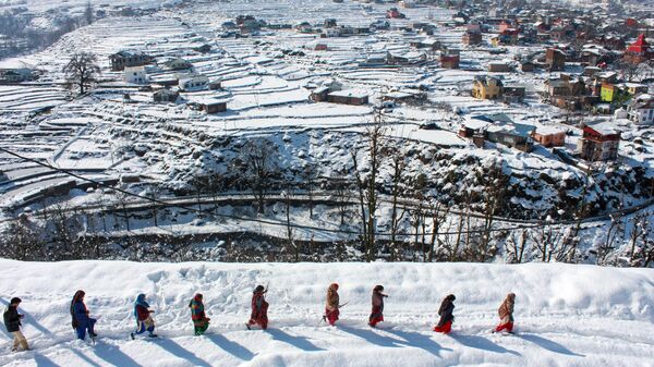 In this photo taken on February 1, 2019, Kashmiri people make their way in the snow from Kansar village after a two-day heavy snowfall that covered the Bhaderwah valley, some 210 kms from Jammu city, in the mountainous Doda district in Jammu-and-Kashmir. - Sputnik India