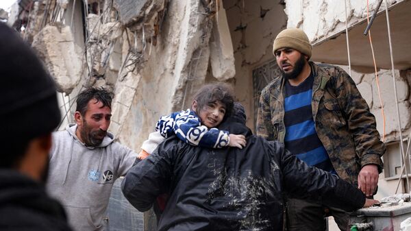 Жители спасают маленького ребенка после землетрясения в городе Джандарис, Сирия - Sputnik भारत