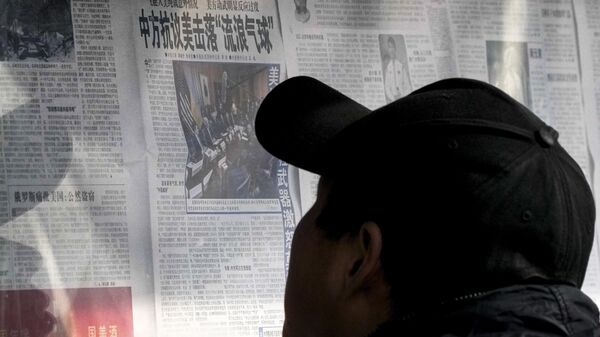 A man reads a newspaper headline reporting on China's protest against the U.S. shooting down a Chinese balloon at a newstand in Beijing, Monday, Feb. 6, 2023. - Sputnik भारत