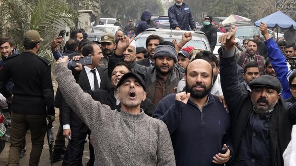 A vehicle carrying Fawad Chaudhry, a senior leader of former Prime Minister Imran Khan's party, is surrounded by media and supporters as it arrives to court in Lahore, Pakistan, Wednesday, Jan. 25, 2023. - Sputnik India