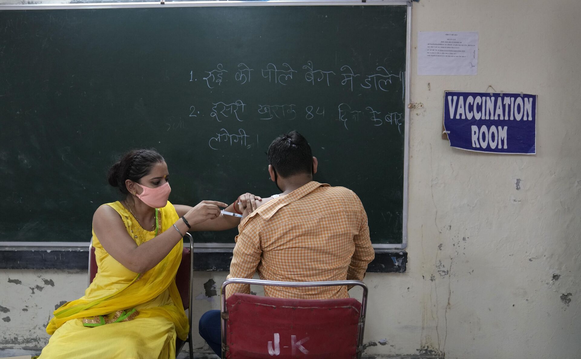 A health worker administers a vaccine for COVID-19 vaccine to a villager in Nizampur, on the outskirts of New Delhi, India, Tuesday, Aug. 24, 2021. - Sputnik भारत, 1920, 25.09.2023