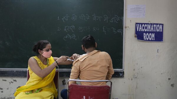 A health worker administers a vaccine for COVID-19 vaccine to a villager in Nizampur, on the outskirts of New Delhi, India, Tuesday, Aug. 24, 2021. - Sputnik India
