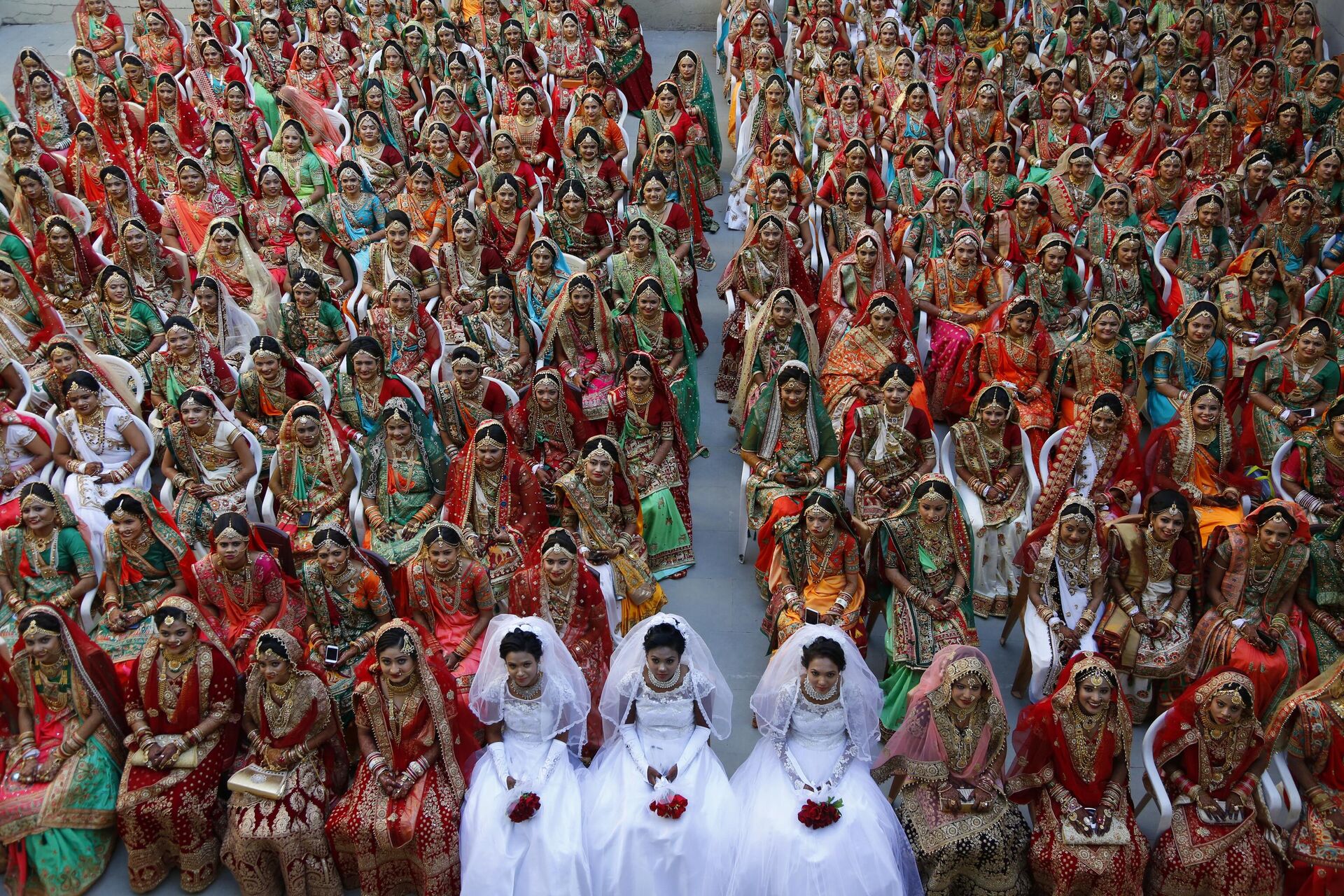 In this Sunday, Dec. 23, 2018, file photo, Indian brides sit together for a group photograph during a mass wedding in Surat, India. - Sputnik India, 1920, 24.09.2023