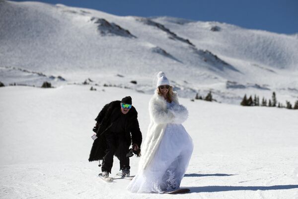Cameron Rae (L) and Emmy Gale (R) ski while celebrating their wedding day during the Loveland Ski Area 26th Annual Valentine's Day Mountaintop Matrimony held near Georgetown, Colorado on February 14, 2017. - Sputnik India