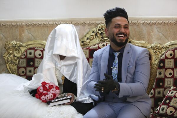 In this Thursday, April 9, 2020 photo, Ahmed Khaled al-Kaabi and his bride Ruqaya Rahim sit during their wedding in Najaf, Iraq, hardest hit town by coronavirus in the country with government banned large public gatherings. - Sputnik India