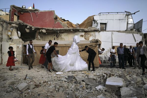 Palestinian bride Rabiha al-Rajby and groom Mohyeldin Nasrallah start their wedding ceremony from the ruins of al-Rajby's home in east Jerusalem neighborhood of Silwan, Saturday, June 11, 2022. - Sputnik India