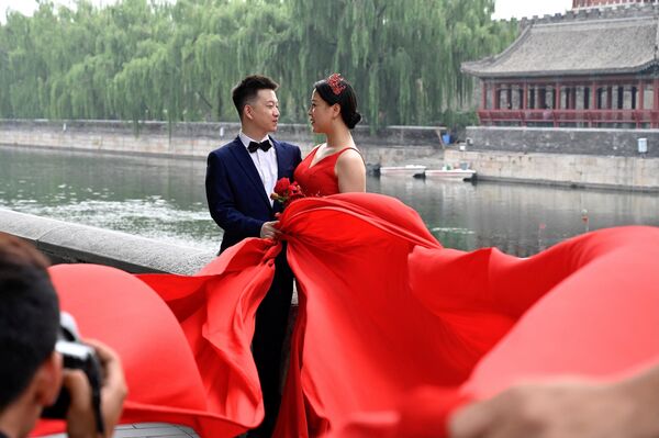 A couple poses for wedding photographs during the Qixi Festival, also known as Chinese Valentine's Day, in Beijing on August 14, 2021. - Sputnik India