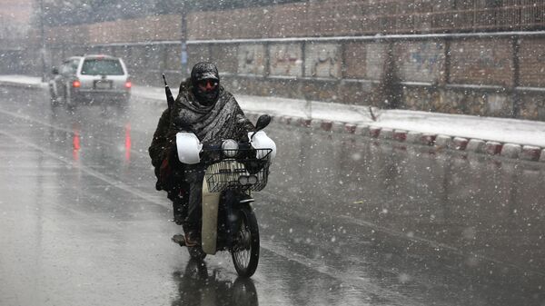 Commuters make their way along a street during snowfall in Kabul on December 29, 2022. - Sputnik India