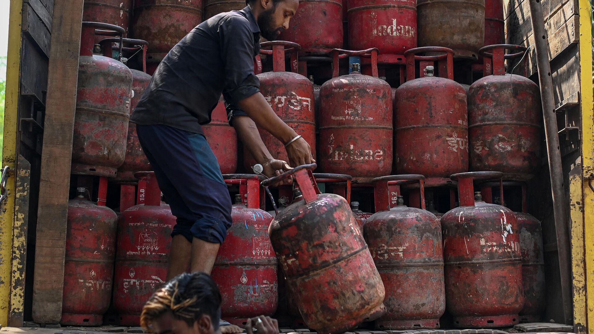 A worker loads empty LPG (Liquified Petroleum Gas) cylinder onto a truck near a depot in New Delhi on May 9, 2022. (Photo by Sajjad HUSSAIN / AFP) - Sputnik India, 1920, 12.02.2023