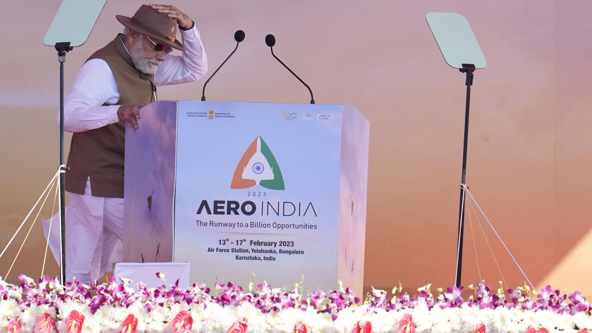 Indian Prime Minister Narendra Modi holds on to his hat as he walks to address the delegates during the inauguration of the Aero India 2023 at Yelahanka air base in Bengaluru, India, Monday, Feb. 13, 2023. - Sputnik India, 1920, 13.02.2023