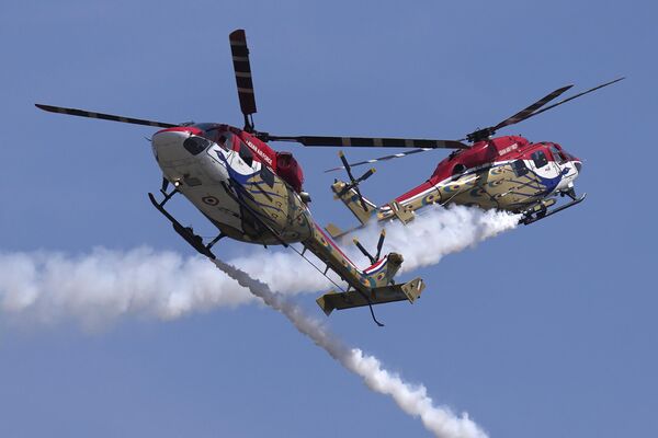 Indian Air Force's Sarang helicopters crisscross each other as they perform aerobatic maneuvers during rehearsals ahead of the Aero India 2023 at Yelahanka air base in Bengaluru, India, Saturday, Feb. 11, 2023.  - Sputnik India