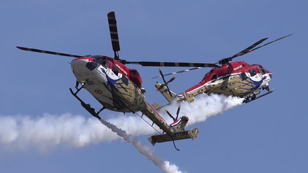 Indian Air Force's Sarang helicopters crisscross each other as they perform aerobatic maneuvers during rehearsals ahead of the Aero India 2023 at Yelahanka air base in Bengaluru, India, Saturday, Feb. 11, 2023.  - Sputnik India