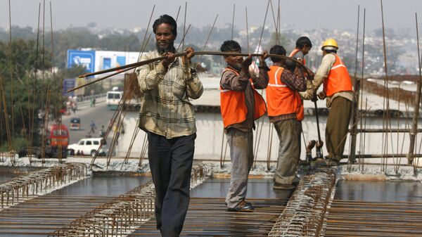 Indian workers carry metal rods on an overpass bridge in Jammu, India - Sputnik भारत