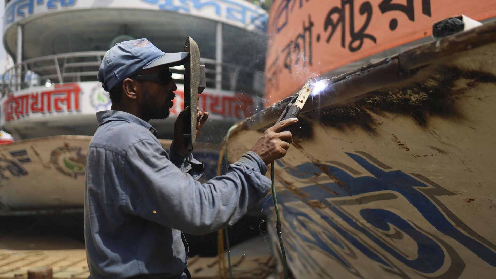 A worker welds the hull of a ferry boat in Dhaka on June 22, 2022. - Sputnik India, 1920, 15.02.2023