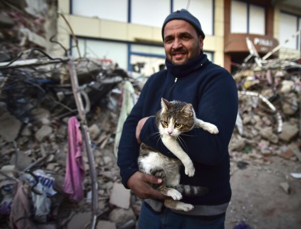 A man holds his cat rescued from a collapsed building in Kahramanmaras, southern Turkey, Saturday, Feb. 11, 2023. - Sputnik India