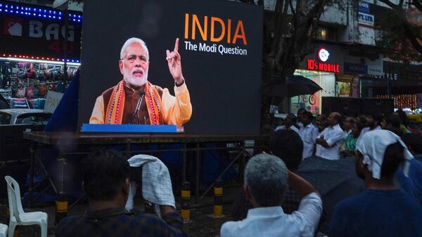 In this file photo taken on January 24, 2023, people watch the BBC documentary India: The Modi Question, on a screen installed at the Marine Drive junction under the direction of the district Congress committee, in Kochi. - Sputnik India
