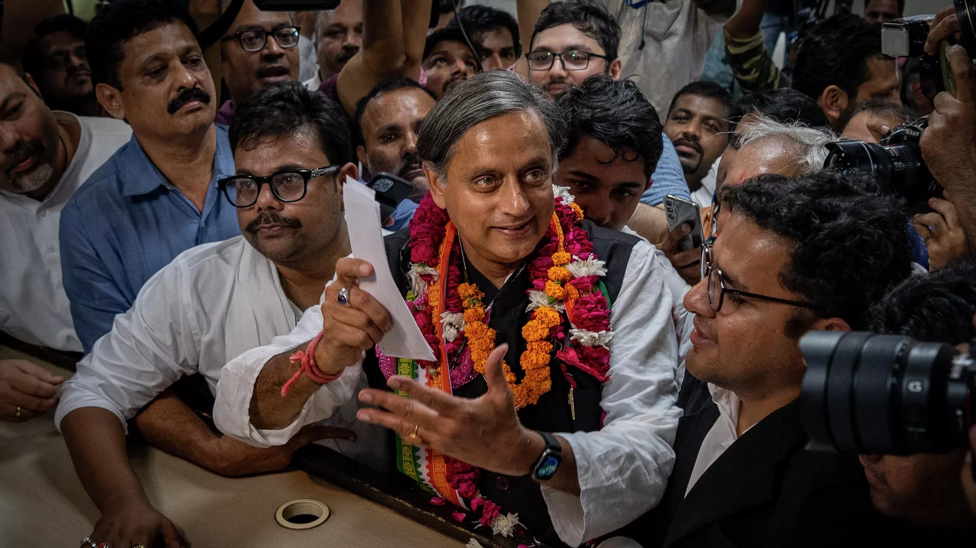 Senior Congress Party leader Shashi Tharoor, right, shows his documents as he files his nomination papers for the position of Congress Party president at the party's headquarter in New Delhi, India, Friday, Sept. 30, 2022.