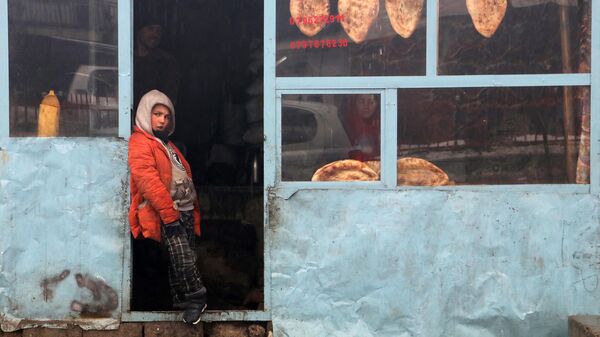 An Afghan boy stands outside a bakery shop in Fayzabad district of Badakhshan province on February 14, 2023. - Sputnik India