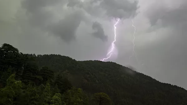 A bolt of lightening is seen above a mountain of the Dhauladhar Range of the Himalayas in Dharmsala, India, Thursday, June 10, 2021. - Sputnik भारत