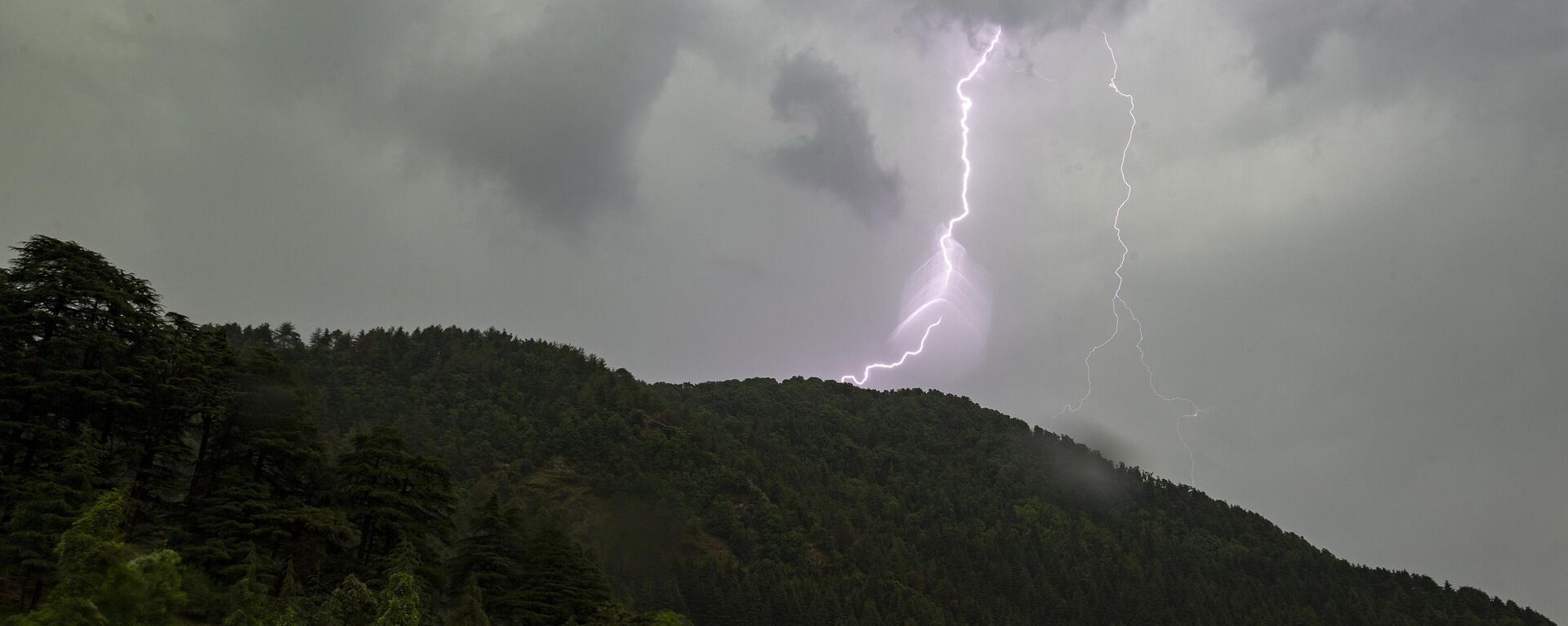 A bolt of lightening is seen above a mountain of the Dhauladhar Range of the Himalayas in Dharmsala, India, Thursday, June 10, 2021. - Sputnik भारत, 1920, 22.02.2023