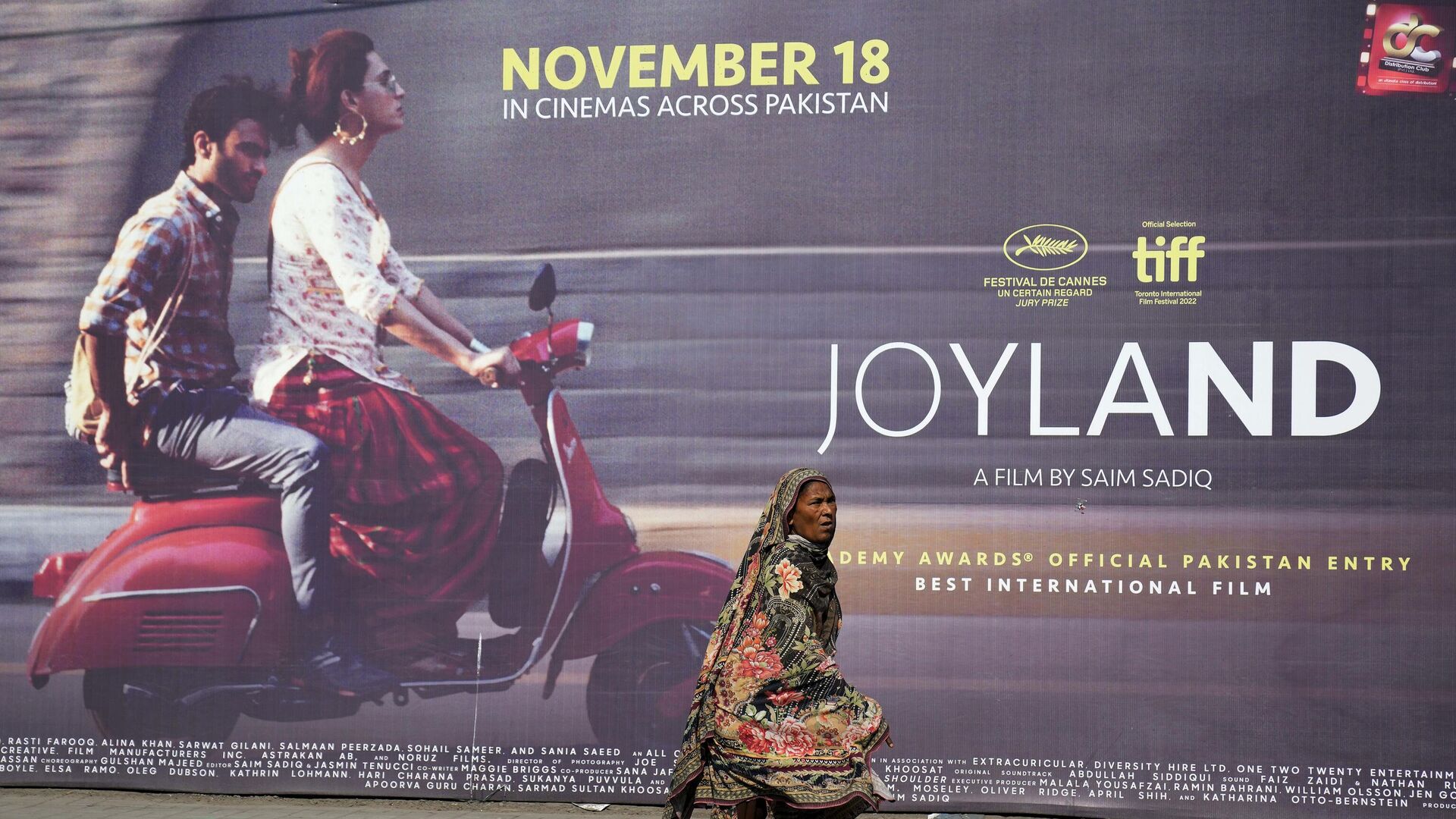 FILE - In this Thursday, Nov. 17, 2022 file photo, a woman walks past a promotional hoarding of an upcoming movie Joyland displayed outside a cinema, in Lahore, Pakistan - Sputnik India, 1920, 27.02.2023