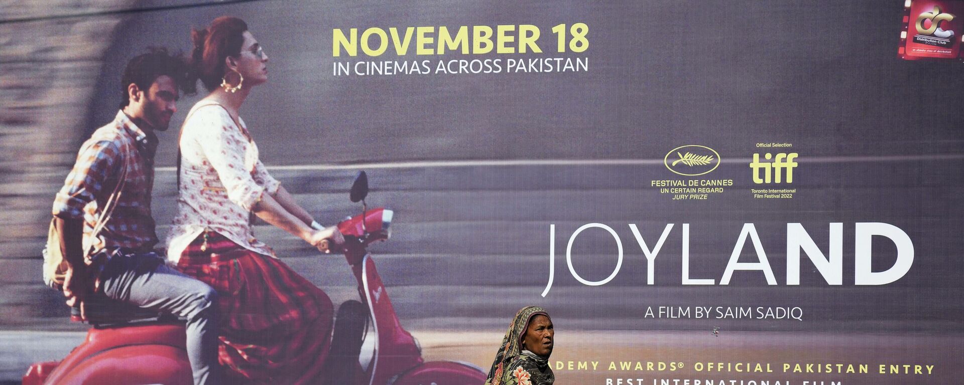 FILE - In this Thursday, Nov. 17, 2022 file photo, a woman walks past a promotional hoarding of an upcoming movie Joyland displayed outside a cinema, in Lahore, Pakistan - Sputnik India, 1920, 27.02.2023