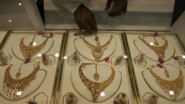 A salesman arranges gold ornaments during East India Jewelry Show - Sputnik भारत