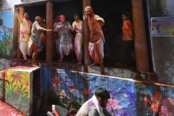Villagers smeared with colours throw water at a motorcyclist during Lathmar Holi in Nandgoan village, 115 kilometers (70 miles) south of New Delhi, India, Wednesday, March 1, 2023. - Sputnik India