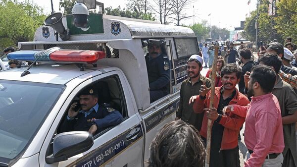 Supporters of former Pakistan's prime minister Imran Khan gather around police van outside his house in Lahore on March 5, 2023 - Sputnik भारत