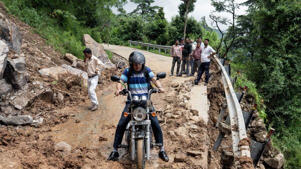 Мотоциклист пытается проехать через перекрытую оползнем дорогу в Дхарамсале, штат Химачал-Прадеш, Индия - Sputnik India