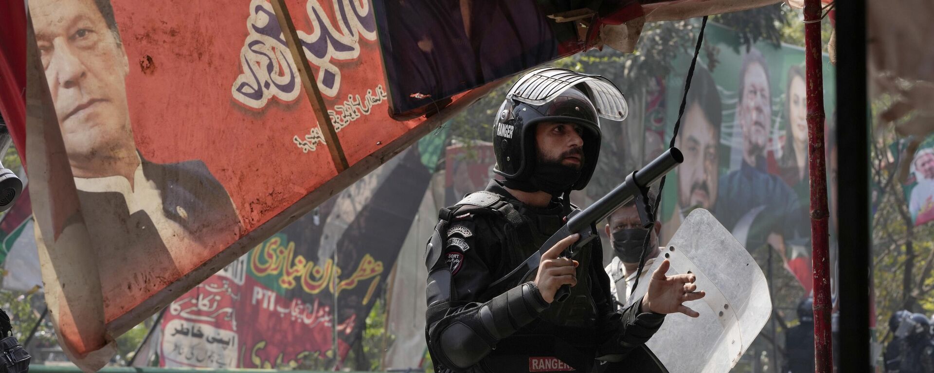 A riot police officer looks on after firing  tear gas to disperse supporters of former Prime Minister Imran Khan during clashes, in Lahore, Pakistan, Wednesday, March 15, 2023. - Sputnik India, 1920, 02.05.2023
